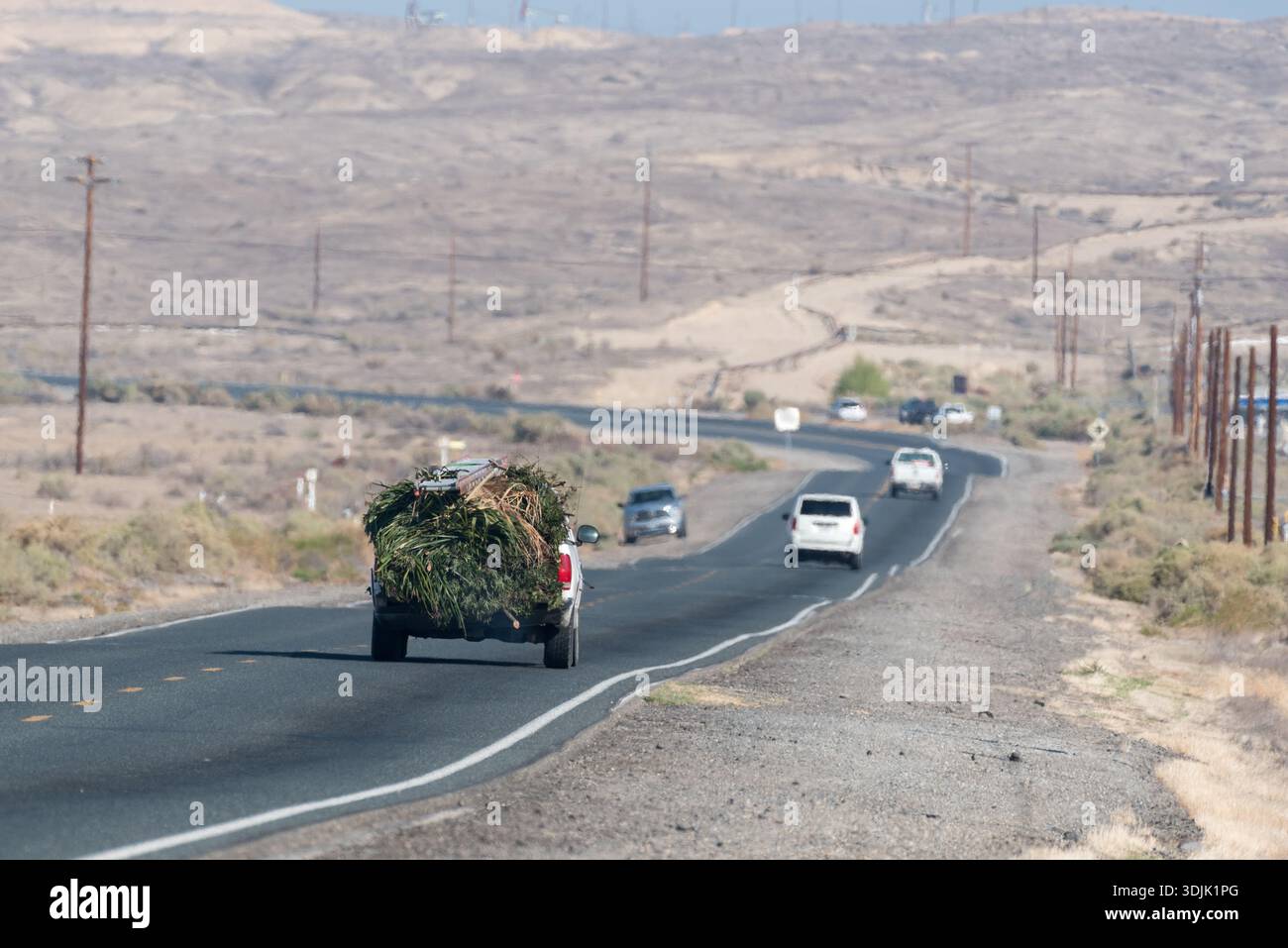 Fahrzeuge auf der Elk Hills Road im San Joaquin Valley, Kalifornien, USA. Stockfoto