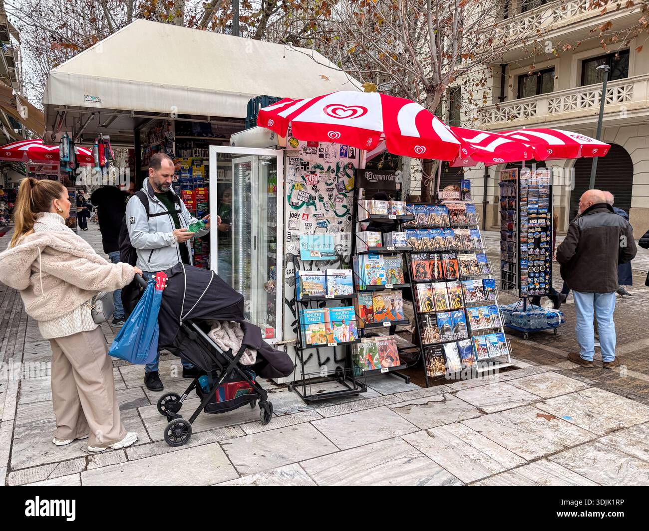 Straßenverkäufer in Athen, der Postkarten und Souvenirs in der Nähe der Akropolis, Griechenland, verkauft. Touristenhandel, Straßenszene mit Leuten, die Waren durchsuchen. Stockfoto