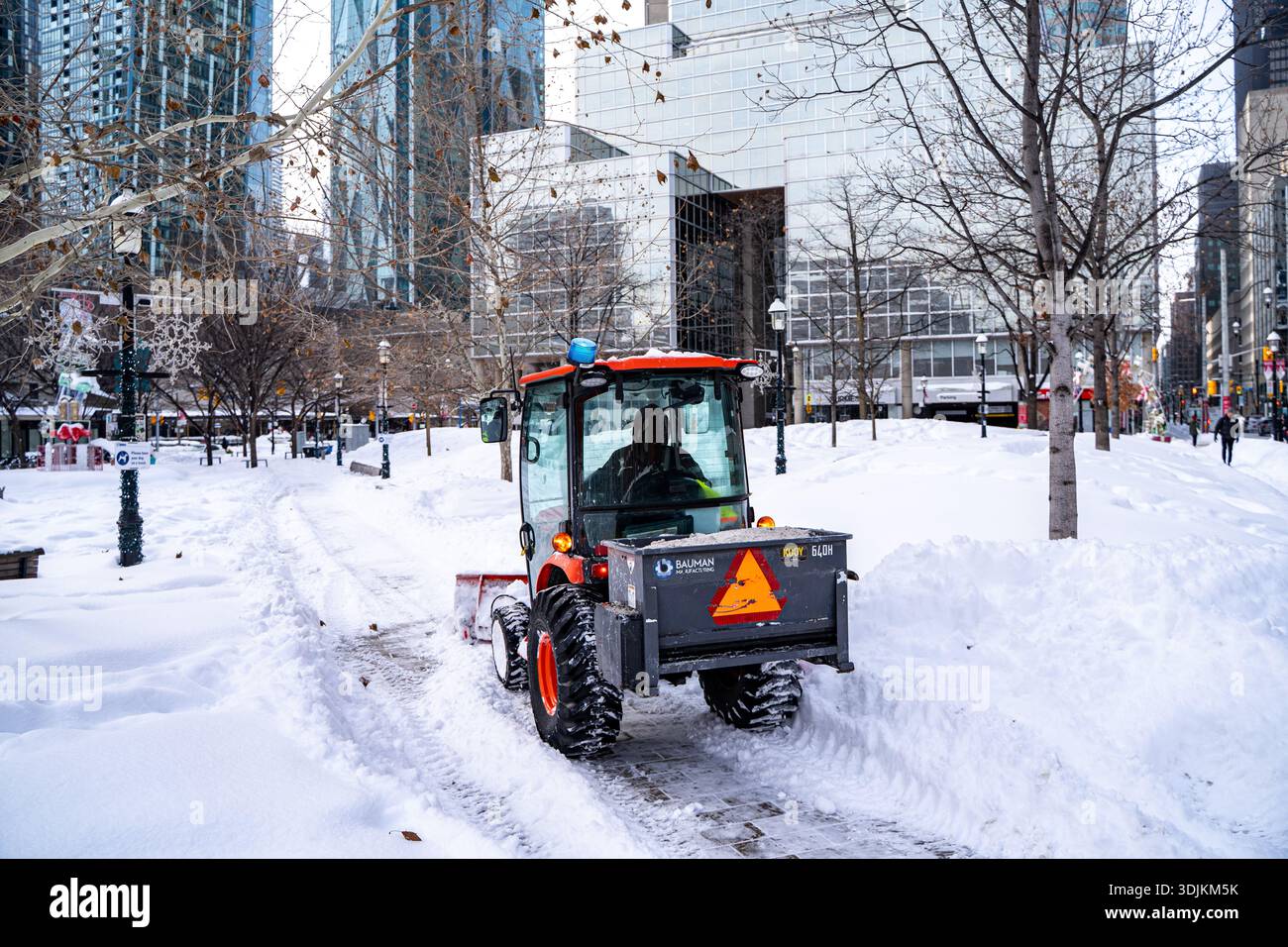 Ansicht eines Mini-Schneeräumungsfahrzeugs, das auf einem Fußgängerweg arbeitet. Toronto, Kanada - 26. Januar 2026. Stockfoto