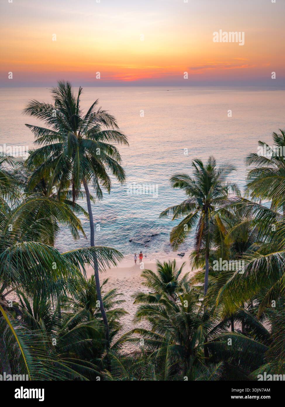 Erleben Sie die Schönheit des Takhian Strandes in Koh Kood, Thailand, während die Sonne untergeht und den Himmel in leuchtenden Farben malt, während Palmen sanft über dem Himmel schwingen Stockfoto