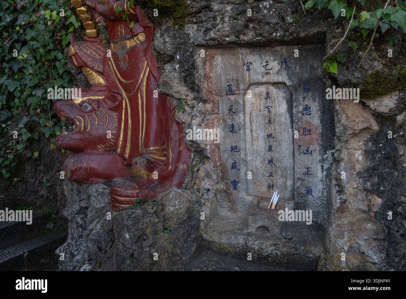 Chinesische Schrift und Schrift in einer Nische auf der Steinseite des Xishan Berges bei Kunming in Yunnan, China. Stockfoto
