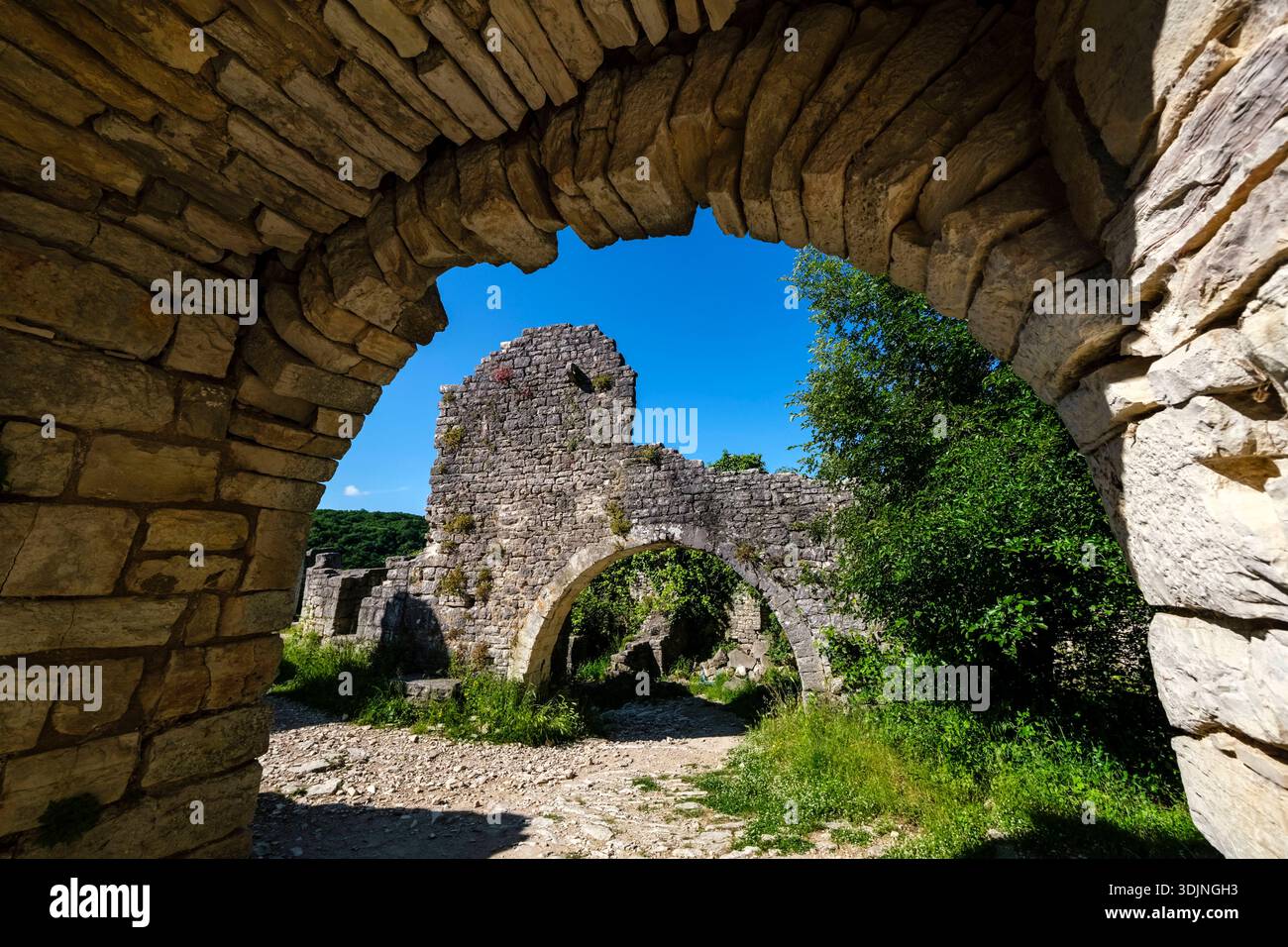Blick durch einen Steinbogen auf die Ruinen von Dvigrad. Ein zweiter Steinbogen und alte Mauern sind in der Ferne sichtbar. Dvigrad Istrien Kroatien FB 202 Stockfoto