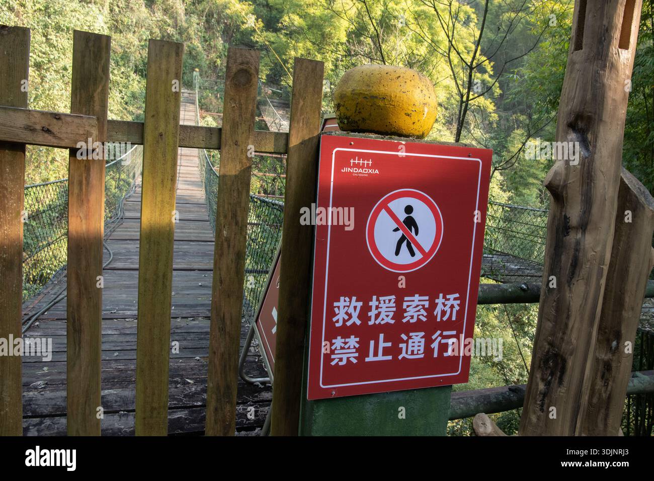 Ein rotes Schild, das darauf hinweist, dass die Seilbrücke dahinter in China für den Zutritt gesperrt ist. Stockfoto