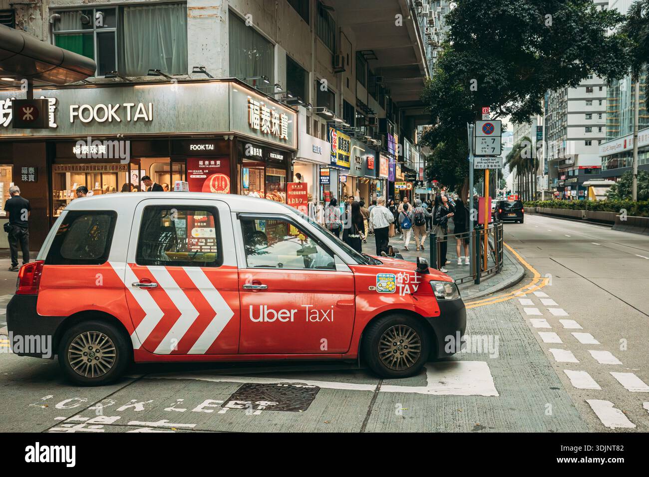 Red Uber Taxi fährt auf einer Straße im Juwelierviertel Tsim Sha Tsui Stockfoto
