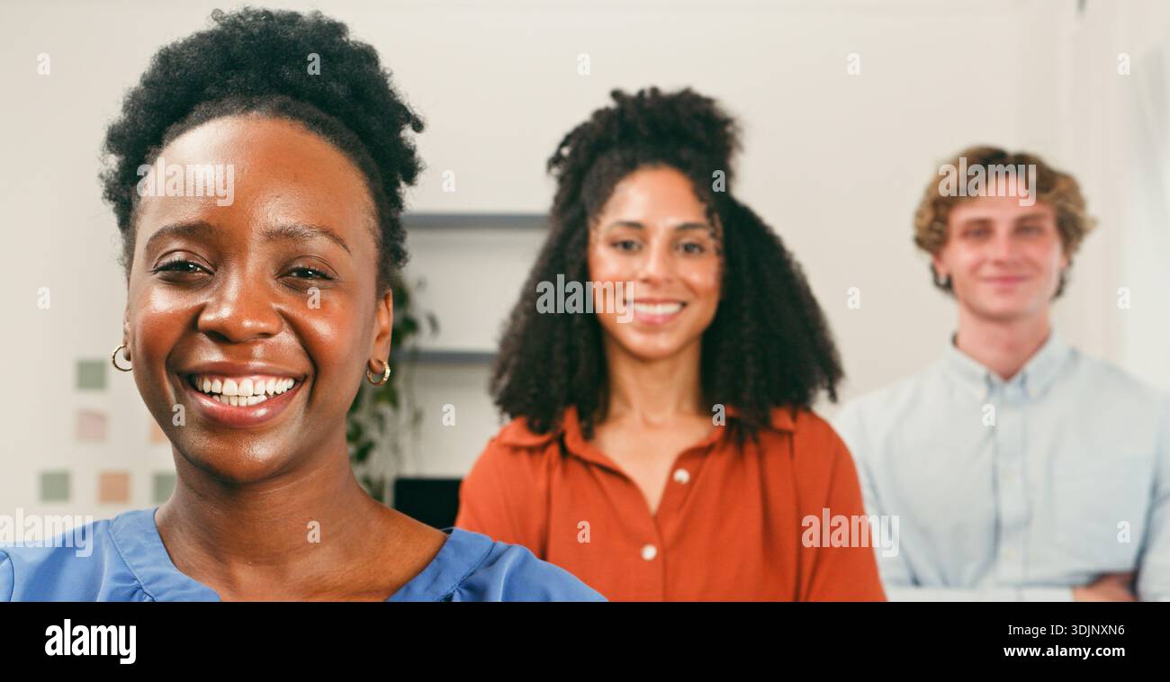 Happy Trio in Office: Lächelnde Kollegen bereit für Zusammenarbeit und Innovation Stockfoto