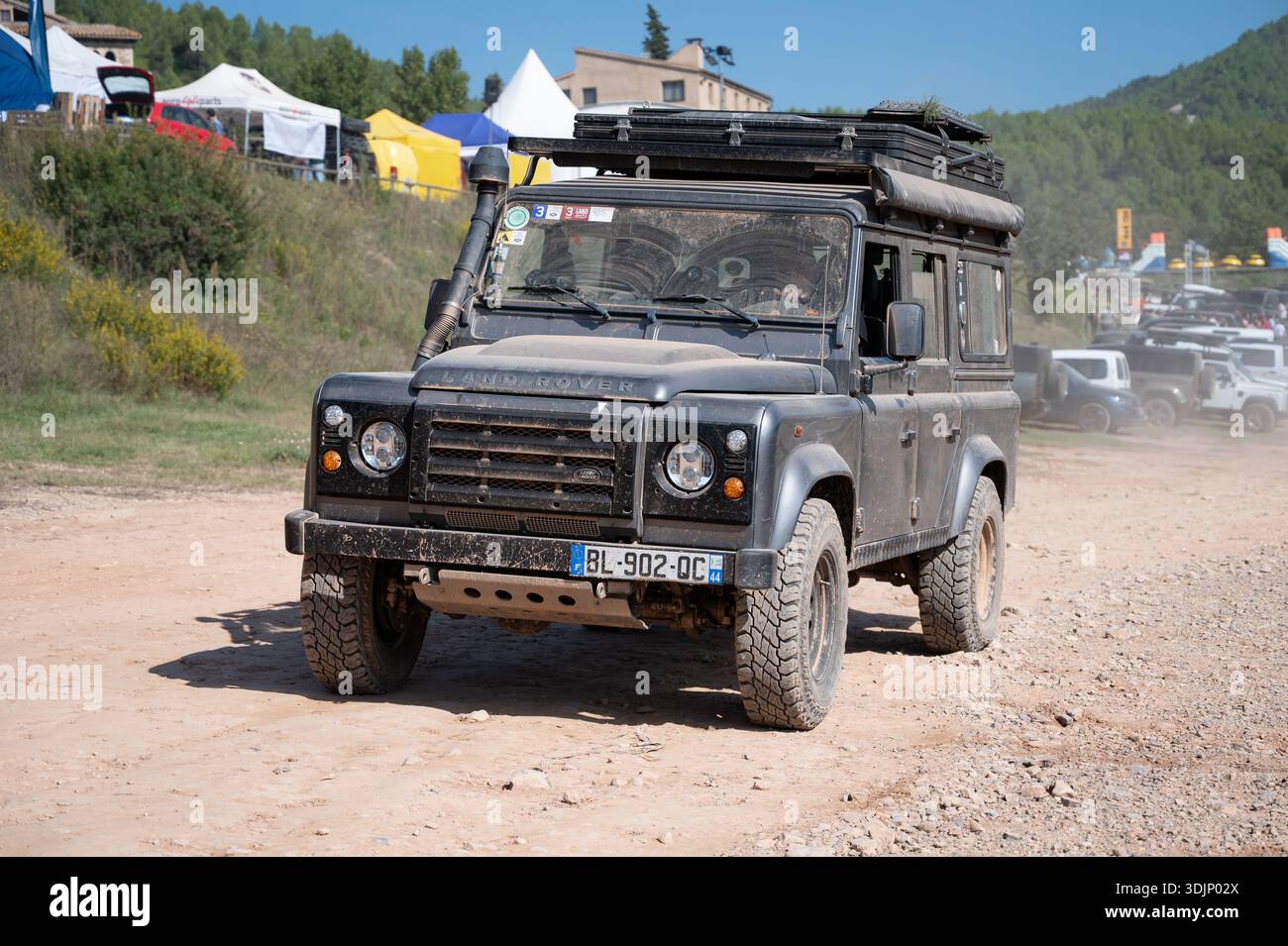 Vorderansicht eines schmutzigen grauen klassischen Land Rover Defender 110 (langer Radstand), ausgestattet für Überlandungen mit Schnorchel, Dachträger, Markise und klappbarem R Stockfoto