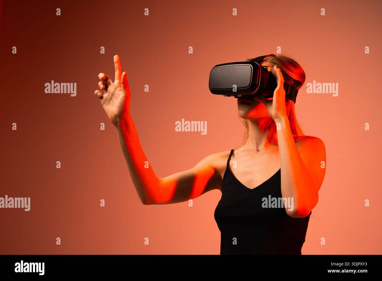 Technologiespezialistin trägt ein VR-Headset und interagiert mit virtueller Schnittstelle, futuristischer Innovation und immersiver digitaler Erfahrung Stockfoto