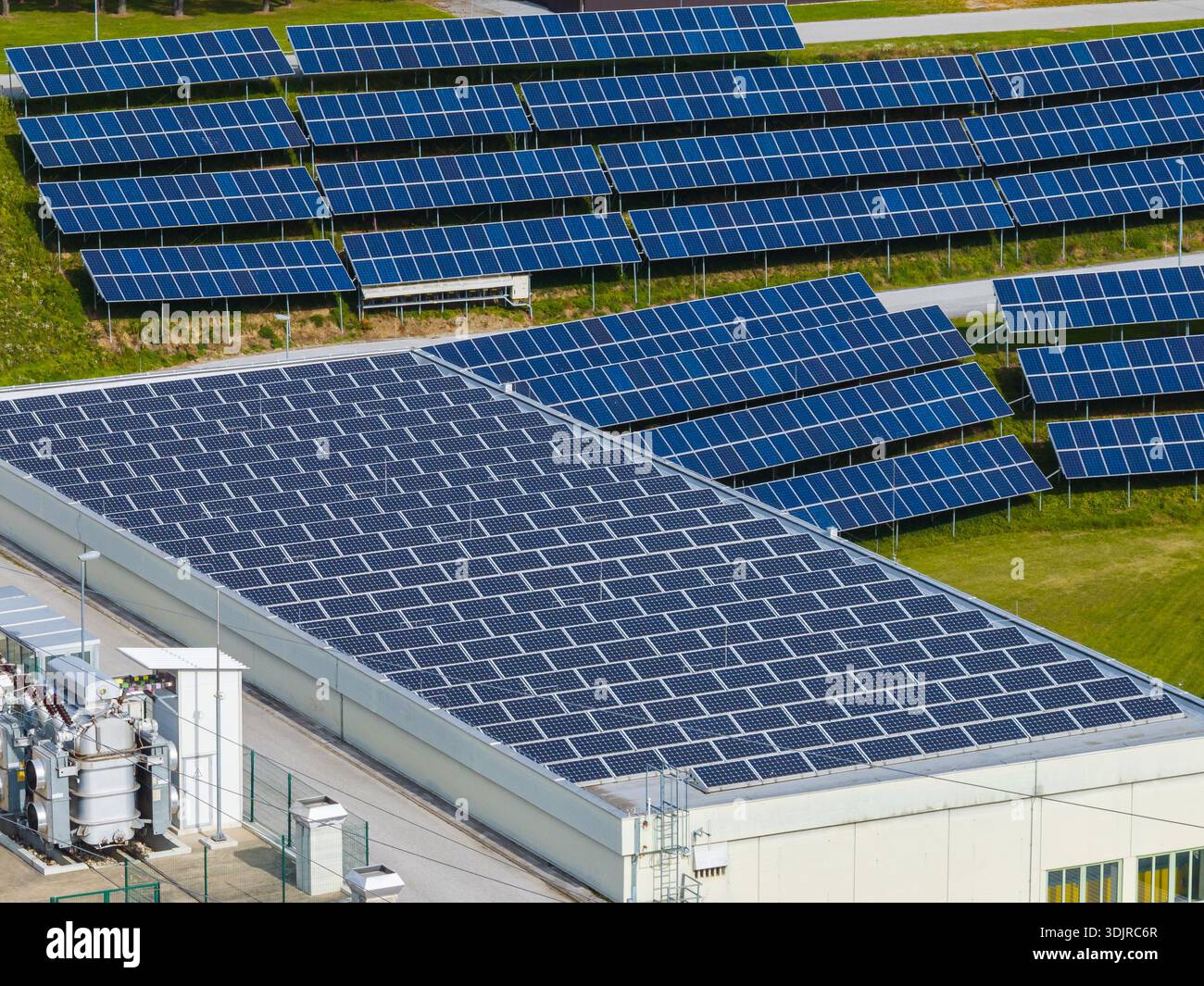 Die Drohne erfasst Solarpaneele, die auf dem Dach des Gebäudes installiert sind, und landet bei Tageslicht an einem Industriestandort. Stockfoto
