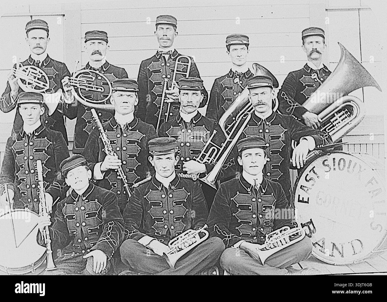 Dies ist die East Sioux Falls (South Dakota) City Band aus dem Jahr 1901. Während dieser Zeit bildeten kleine Städte in South Dakota Gemeindebands für lokale Unterhaltung und Veranstaltungen. Im Jahr 1901 war East Sioux Falls eine blühende „Boomstadt“, die sich um die rosa Quarzit-Steinbruchindustrie drehte. Zu ihrem Höhepunkt während dieser Zeit zählte die Stadt etwa 600 Einwohner und verfügte über Annehmlichkeiten wie ein Postamt, ein Rathaus und mehrere Saloons. Beachten Sie, dass dies eine Blaskapelle mit schicken Uniformen ist; perfekt für Stadtparaden. Stockfoto