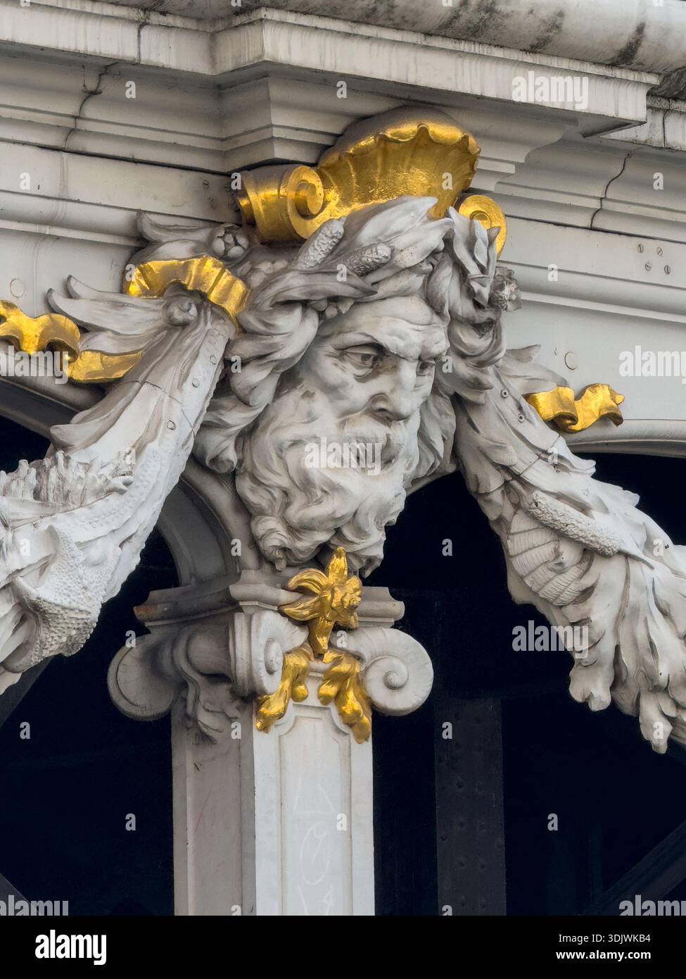 Ein vergoldetes Mascaron oder ein gemeißeltes Gesicht, das Teil der umfangreichen Dekoration auf der Brücke Pont Alexandre III in Paris, Frankreich, ist. Stockfoto