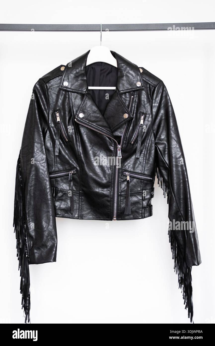 Schwarze Bikerjacke aus Kunstleder mit silbernen Reißverschlüssen und langen Fransen an den Ärmeln für den Einzelhandel Stockfoto