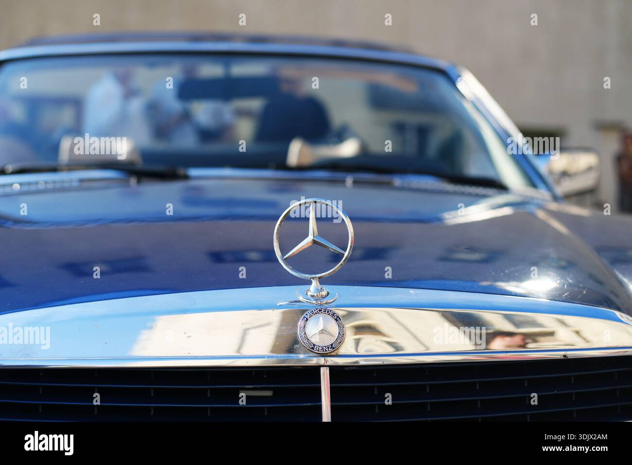 Minsk, Weißrussland - 10. April 2025: Vorderansicht eines Mercedes-Benz-Klassikers mit Emblem, der Luxus-Design und Automobil-Exzellenz in einer lebendigen Atmosphäre unterstreicht Stockfoto