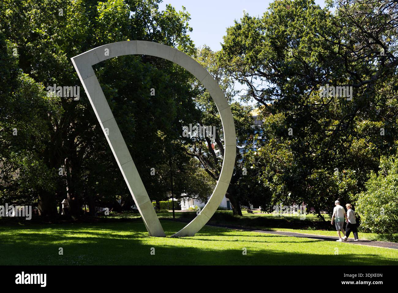 Moderne abstrakte Skulptur im Albert Park, Auckland, mit einem Spaziergang durch sonnendurchflutete Rasenflächen unter alten Bäumen. Stockfoto