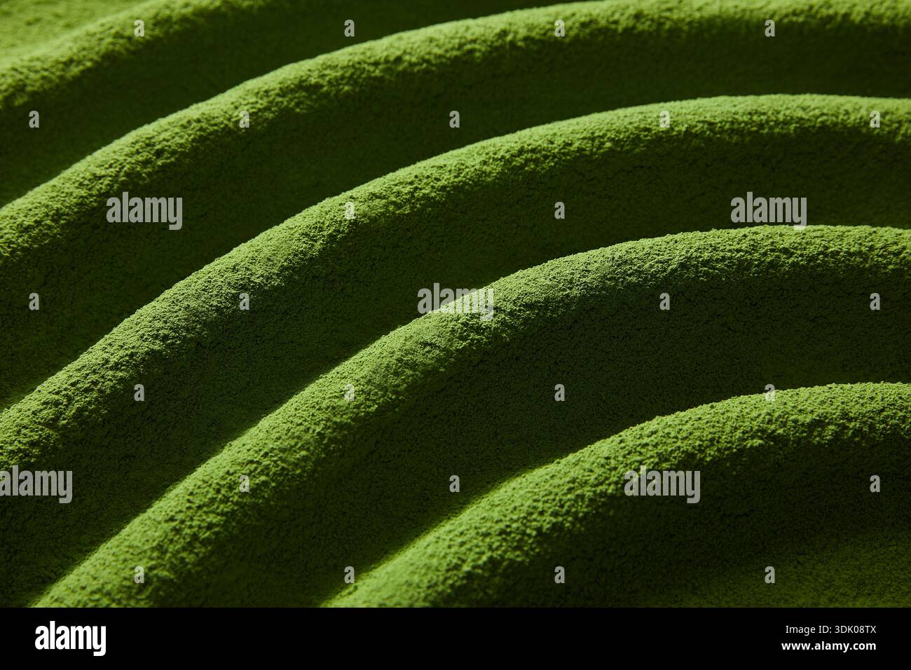 Hochwertige Textur aus Bio-Matcha-Grüntee in welligem Muster Stockfoto