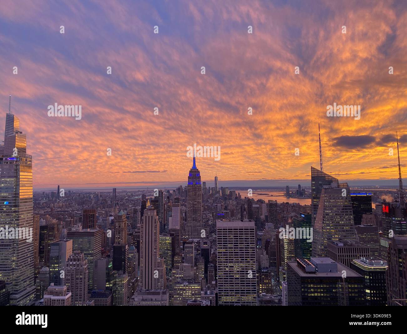 Skyline von New York City bei Sonnenuntergang mit dem Empire State Building, Blick vom Rockefeller Center. - Smartphone-aufgenommenes Stockfoto