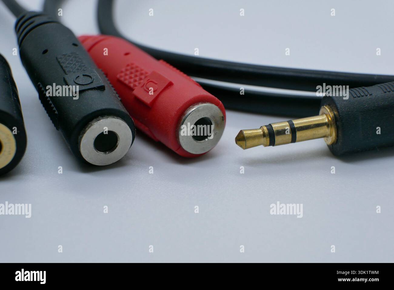 Nahaufnahme eines 3,5-mm-Audio-Buchsensplitters mit roten und schwarzen RCA-Buchsen. Studio-Aufnahme auf neutralweißem Hintergrund für Sound, Musik, hifi-anlage und recor Stockfoto
