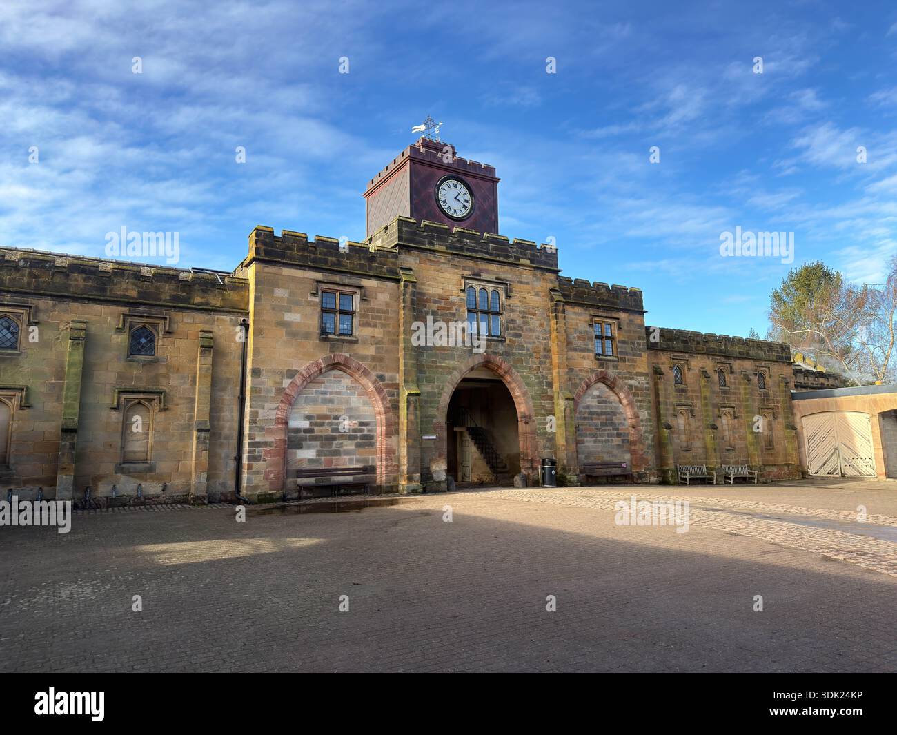 Elvaston Castle Country Park Stables, Clock Tower und hölzerne geschnitzte Sitze an einem sonnigen Wintertag, Derby, Derbyshire.England.UK - Smartphone-aufgenommenes Stockfoto