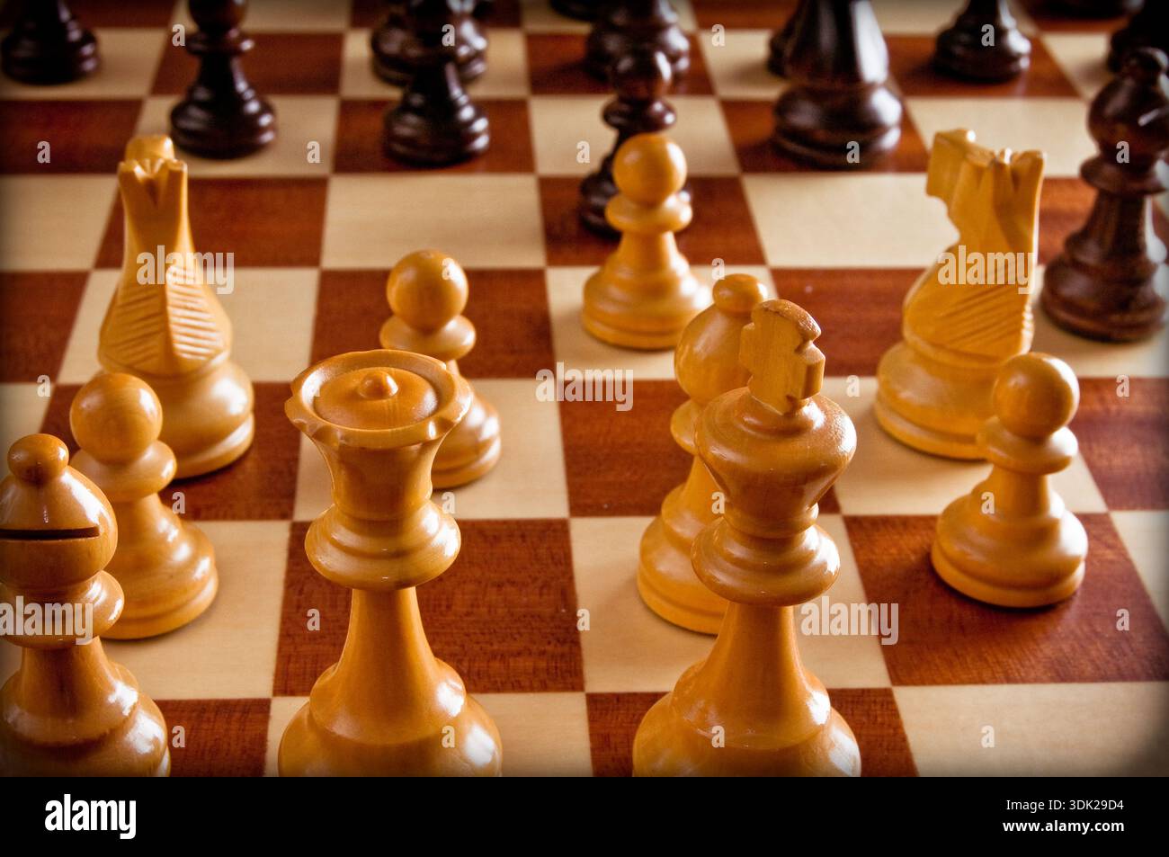 Hölzerne Schachfiguren auf einem Schachbrett, die Strategie, Planung und Entscheidungsfindung in einem Wettkampf darstellen Stockfoto