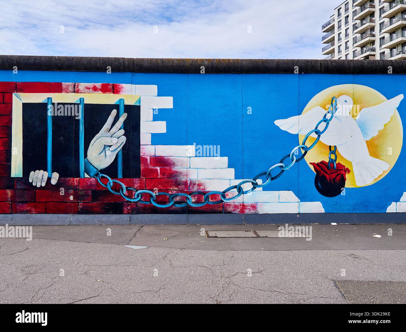 Berlin, Deutschland - Mai 2024: Graffiti an der Berliner Mauer in der East Side Gallery. Wandgemälde „die Freiheit“ mit einer weißen Taube und Händen hinter b Stockfoto