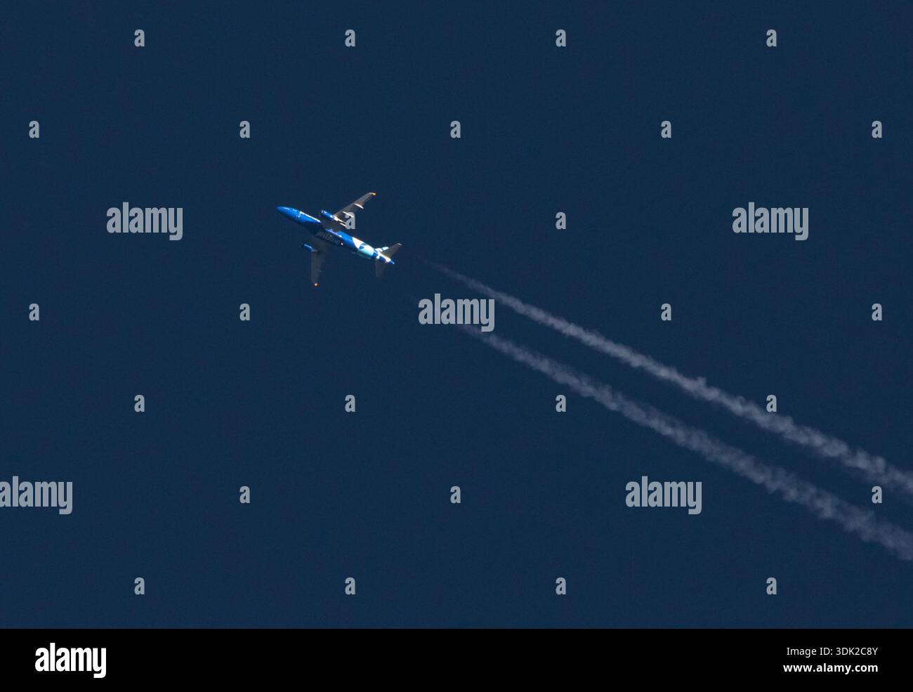 CHARLOTTE, NC (USA) - 28. Januar 2026: Ein Passagierflugzeug von Jet Blue überquert in großer Höhe Kondensstreifen in tiefblauem Himmel. Stockfoto