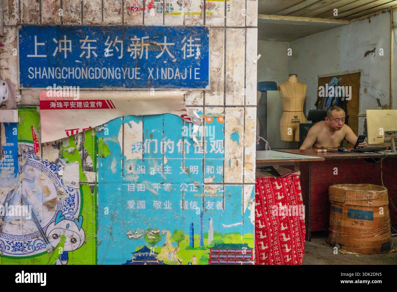 Ein Mann stellt Kleidung in seinem Geschäft in den Datang-Dörfern her. Guangzhou. China Stockfoto