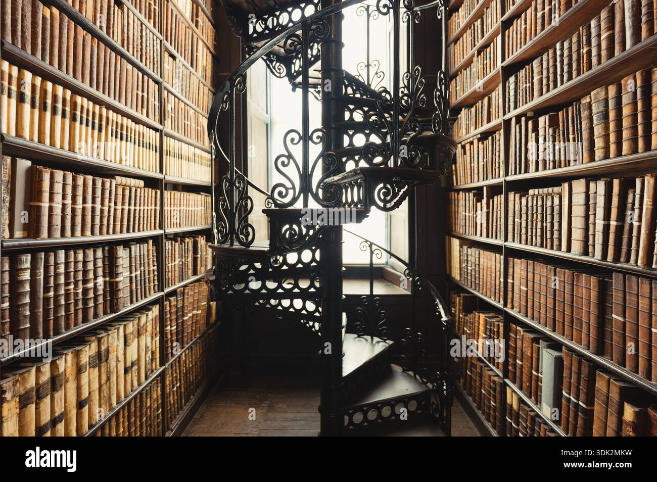 Alte Bibliothek mit Wendeltreppe und antiken Büchern. Stockfoto