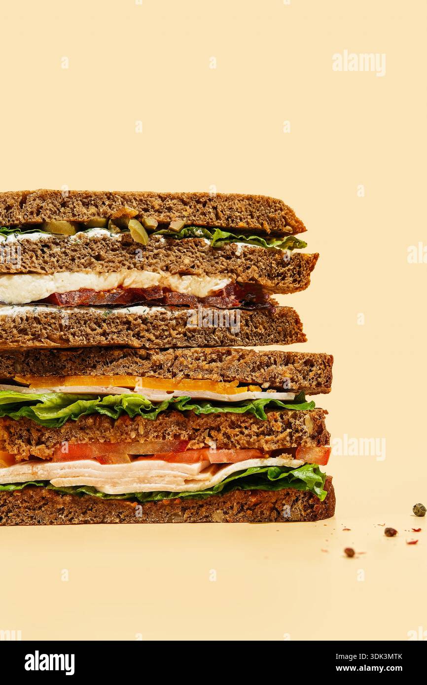 Dunkles Brot Mit Frischen Füllungen. Vertikale Zusammensetzung Eines Deftigen Sandwiches Mit Gemüse Und Eiern Stockfoto
