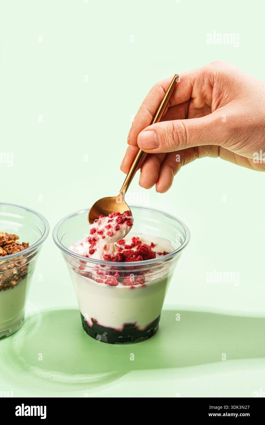 Joghurt Mit Beeren Und Müsli. Microinfluencer Erfasst Die Action Von Parfait Mit Weichem Hintergrund Stockfoto