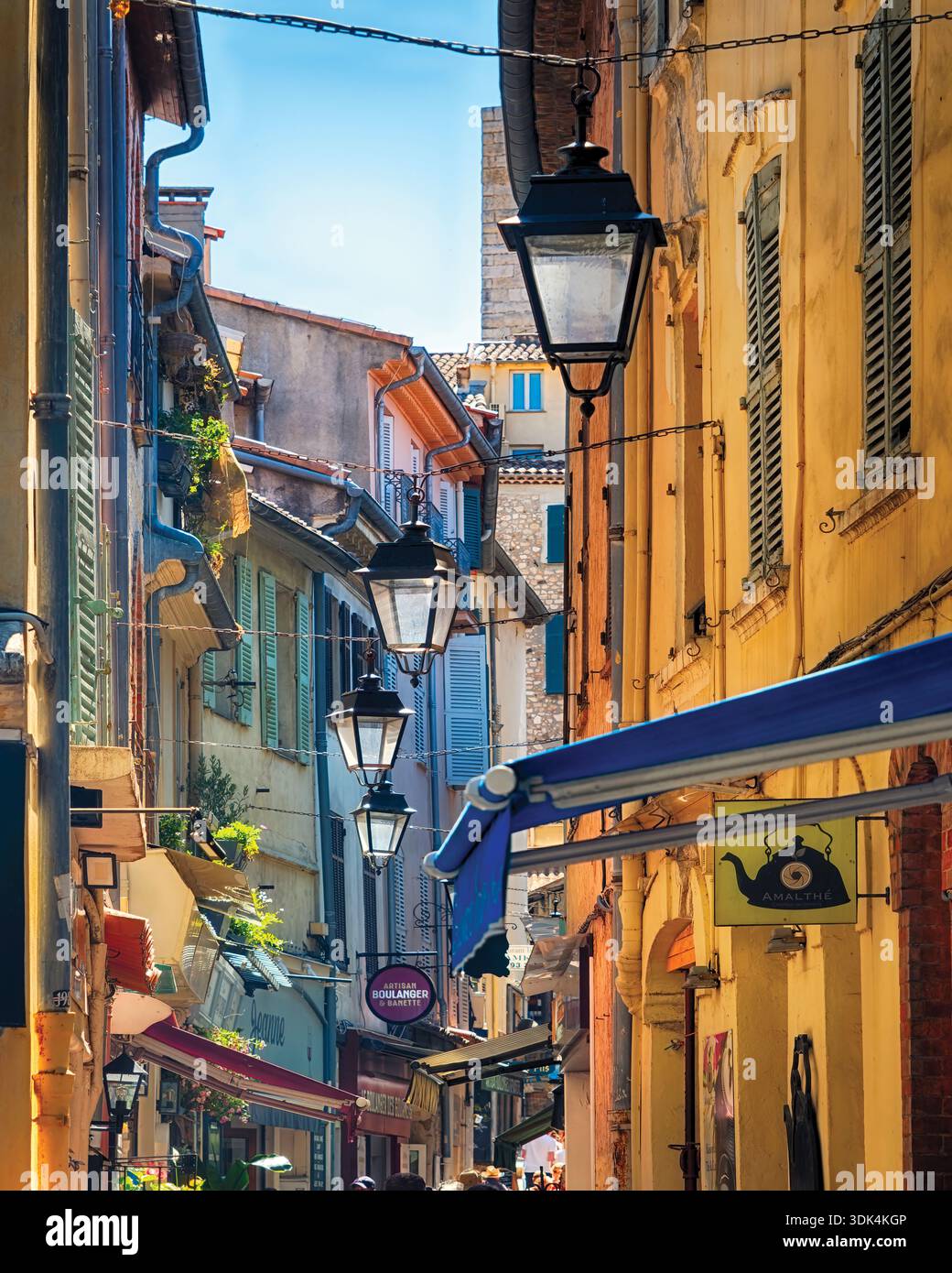 Hausfassaden einer charmanten Straße mit pastellfarbenen Häusern und hängenden Straßenlaternen, Antibes, Alpes Maritimes, Cote D'Azur, französische Riviera, F Stockfoto