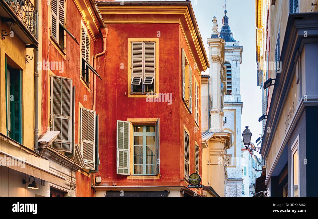 Low Angle Street Blick auf traditionelle Häuser und den Turm der Cathédrale Sainte-Réparate de Nice, Alpes Maritimes, Cote D'Azur, Frankreich Stockfoto