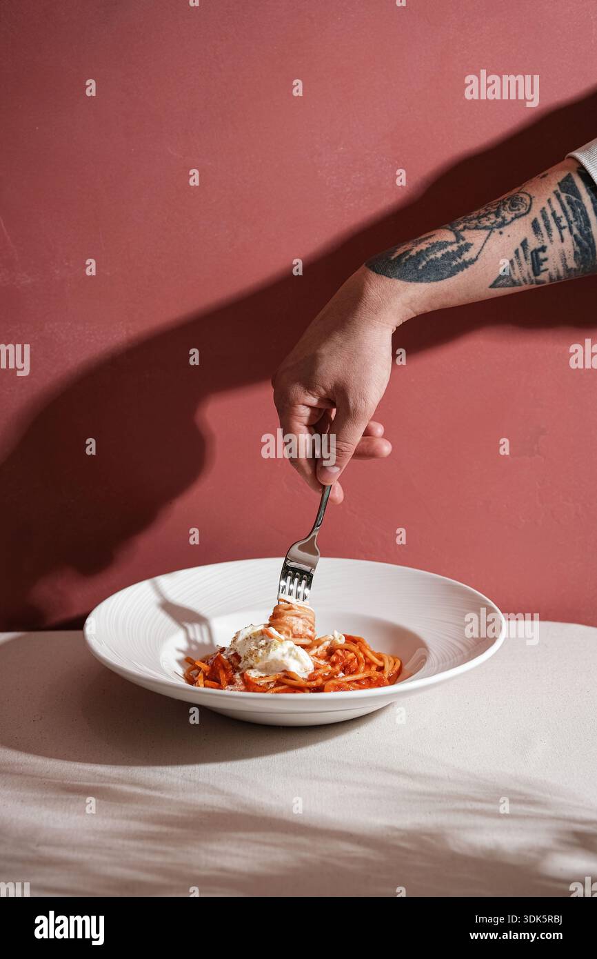 Tätowierte, handgedrehte Spaghetti, intime Küche Moment Stockfoto