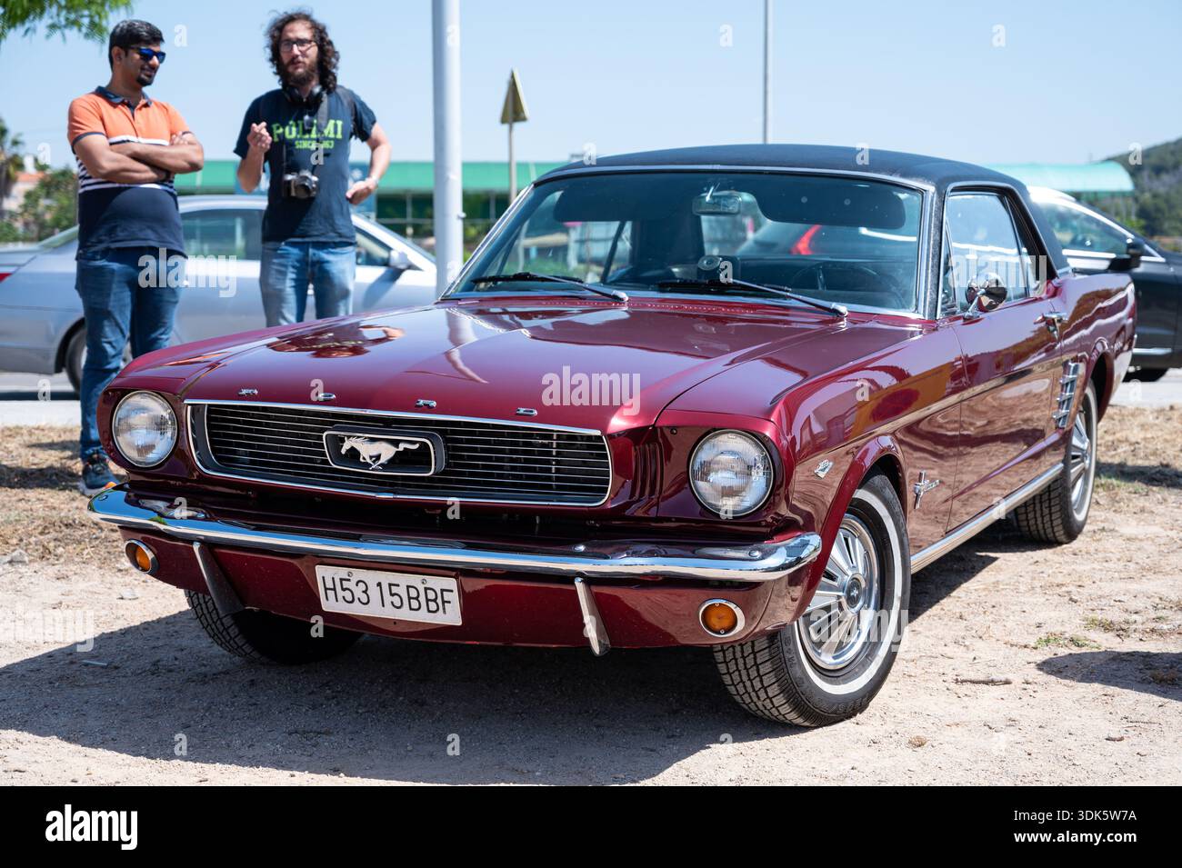 Vorderansicht eines klassischen Ford Mustang 289 der 1. Generation. Dieser legendäre Oldtimer verfügt über ein zweifarbiges, burgunderrotes und schwarzes Dach mit zwei Personen in der Ba Stockfoto