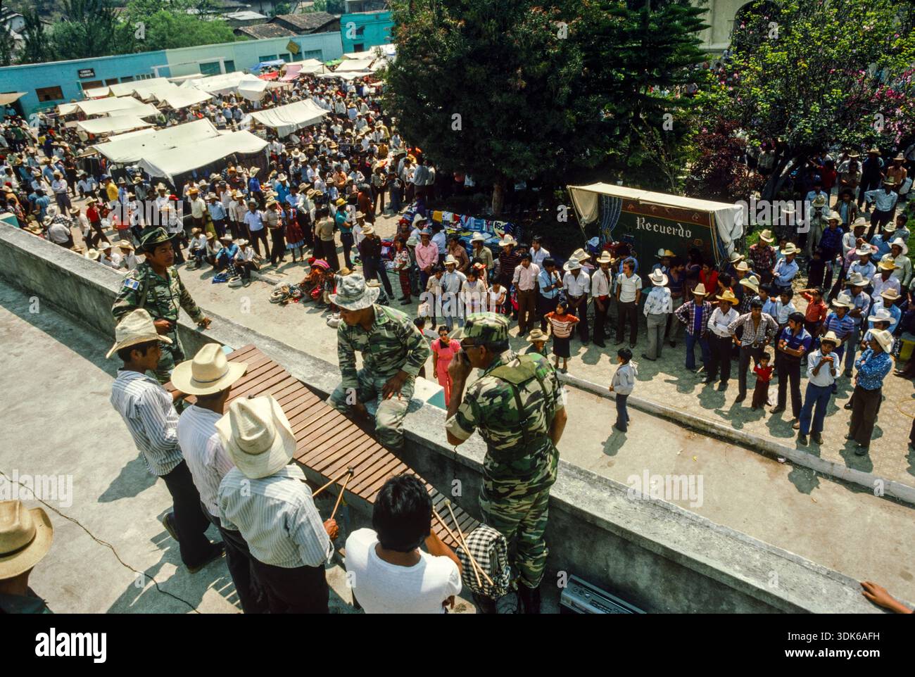 Guatemala, April 1986; Hauptmann Mario Mendizabal, ein Radiosprecher, bis er von Präsident Rios Montt in die Armee aufgenommen wurde, hält Menschen am Markttag in San Pedro Necta, Huehuetenango. Das guatemaltekische Militär startete ein ziviles Militärprogramm, um ihr verheerendes Image der ländlichen Bevölkerung zu vermitteln Stockfoto