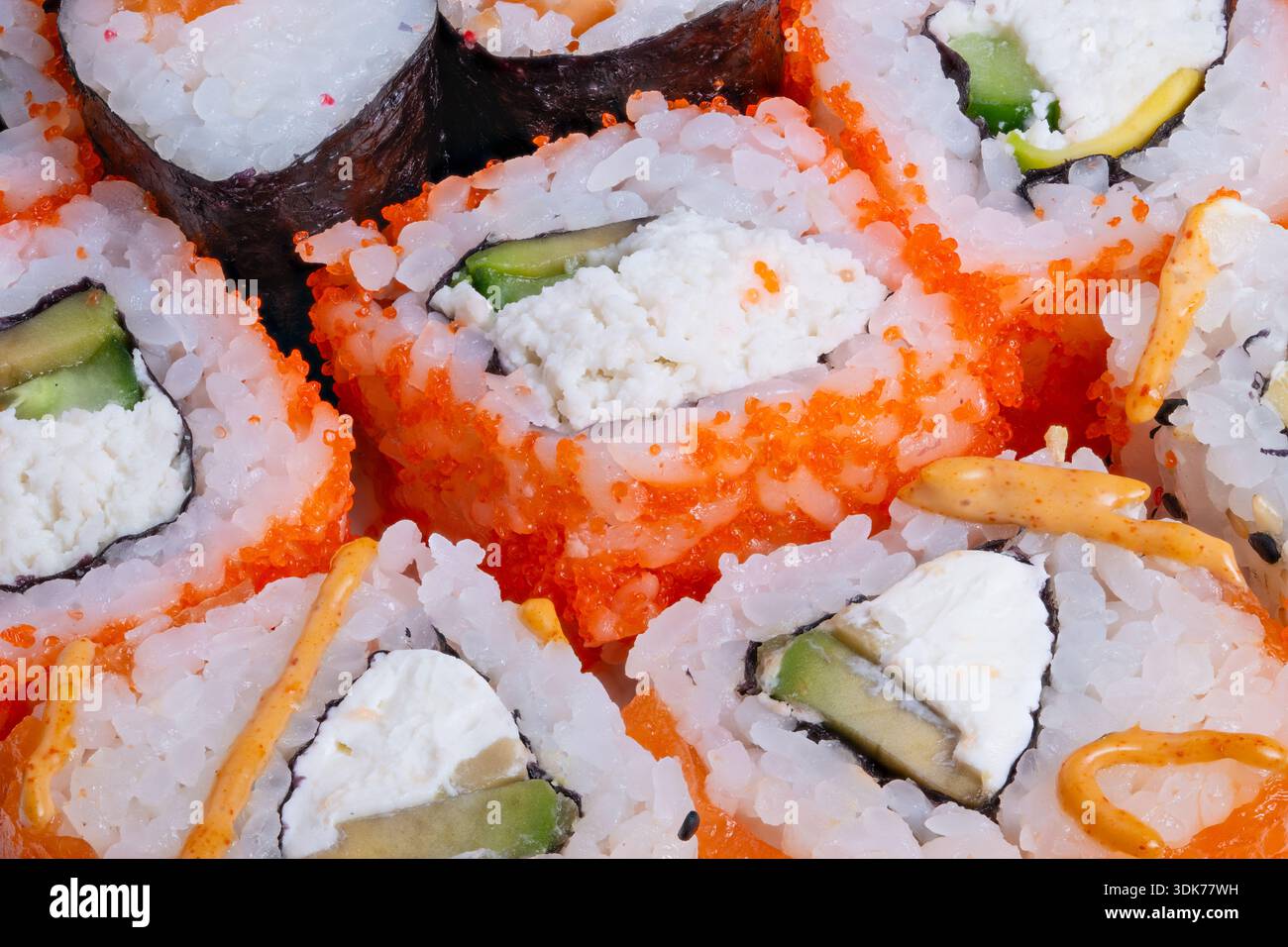 Sushi-Brötchen aus der Nähe mit cremiger Füllung, Gurken- und Lachsakzenten, knuspriger Reh-Textur, Tischstimmung für Restaurantmenü und Food Blogger-Verkostung Stockfoto