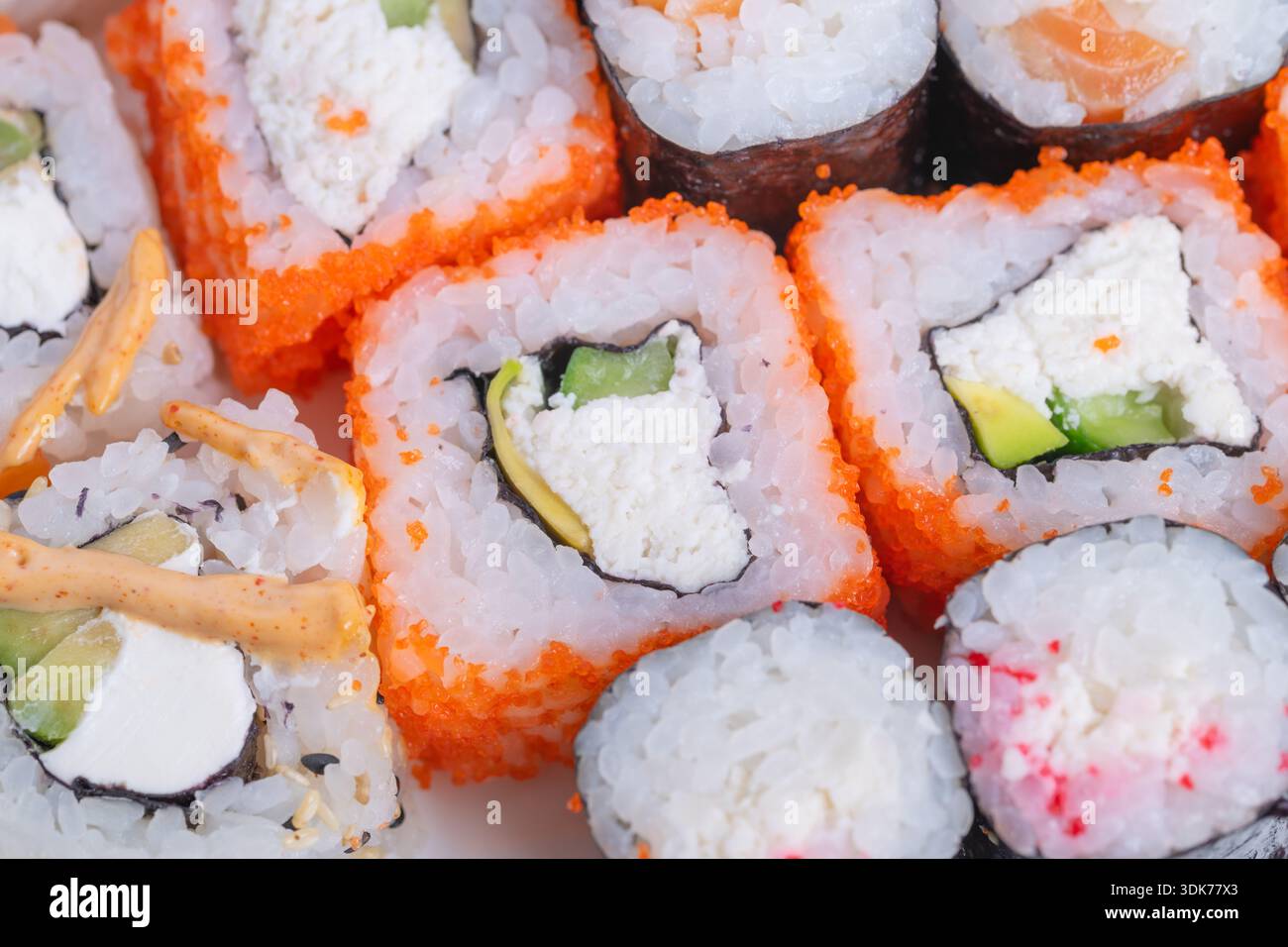 Gemeinsames farbenfrohes Sushi. Eine intime Platte mit lebhaftem strukturiertem Sushi. Wunderschön gestaltetes Sushi-Set für ein romantisches und raffiniertes kulinarisches Erlebnis Stockfoto