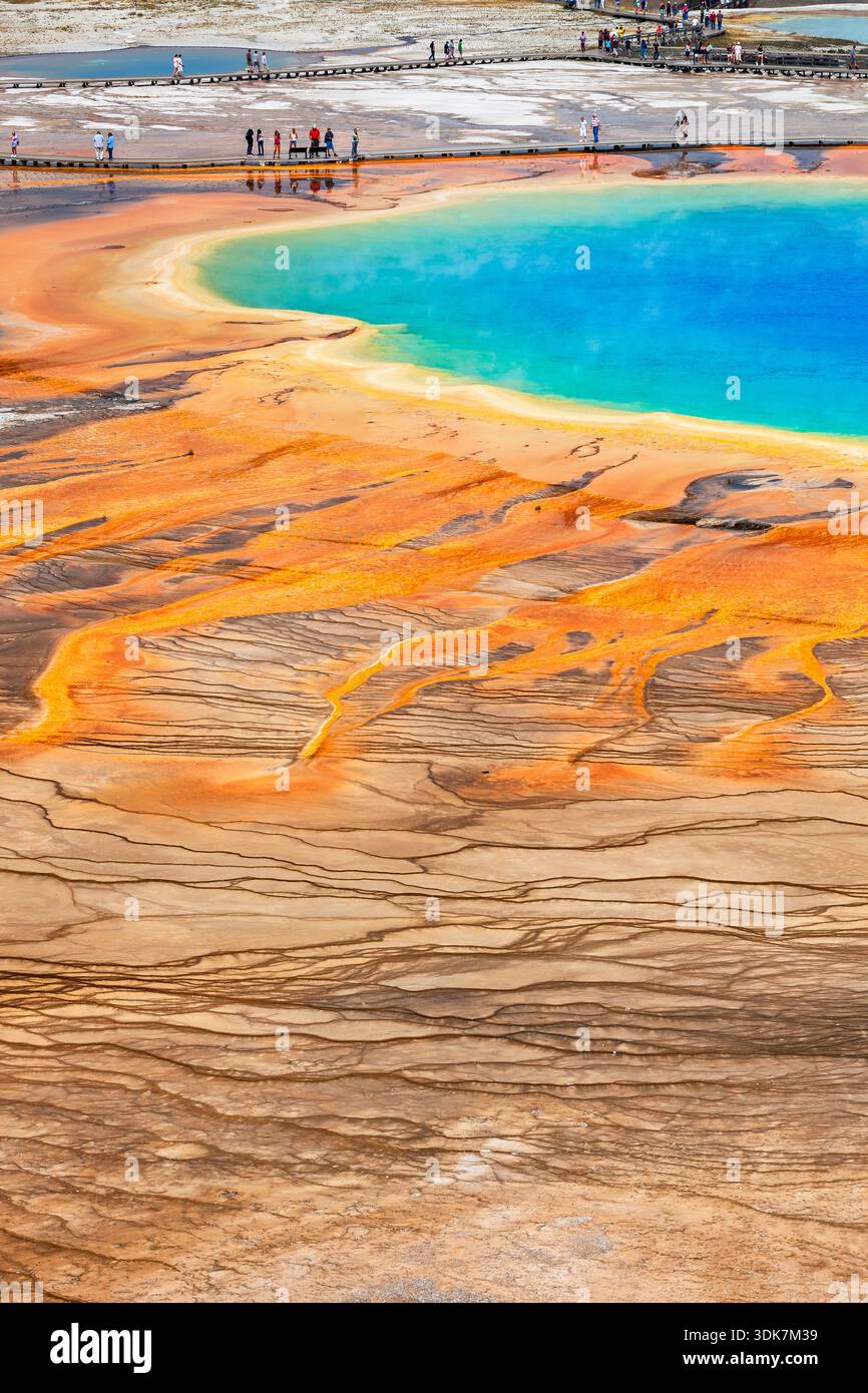 Farbenfrohe Grand Prismatic Spring im Midway Geyser Basin von Yellowstone mit lebhaften Regenbogenfarben und Touristen auf der Promenade. Stockfoto
