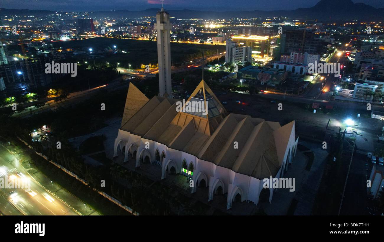 Majestätisch steht das nationale Christliche Zentrum von Abuja aus der Vogelperspektive vor dem schwindenden Licht, dessen spitzes Dach und Turm den Abendhimmel durchdringen Stockfoto