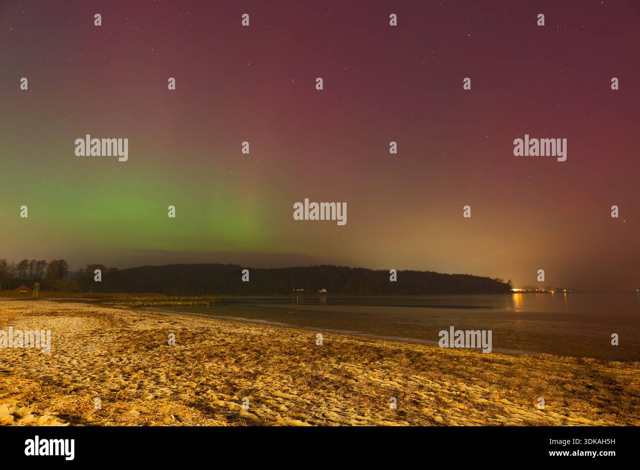 Leuchtende grüne Polarlichter tanzen über den Meereswellen. Ideal als Filmhintergrund, als Inspiration für Reisen oder als Titelbild für Naturdokumentationen. Stockfoto