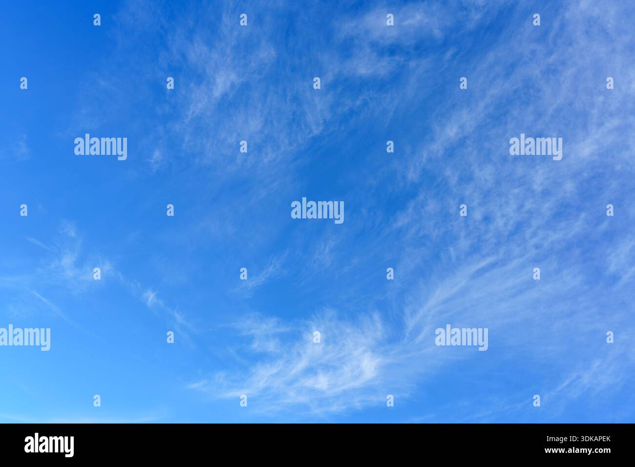 An einem sonnigen Tag ziehen sich die Wolken langsam über einen hellblauen Himmel, ohne dass Anzeichen von Regen zu sehen sind. Stockfoto