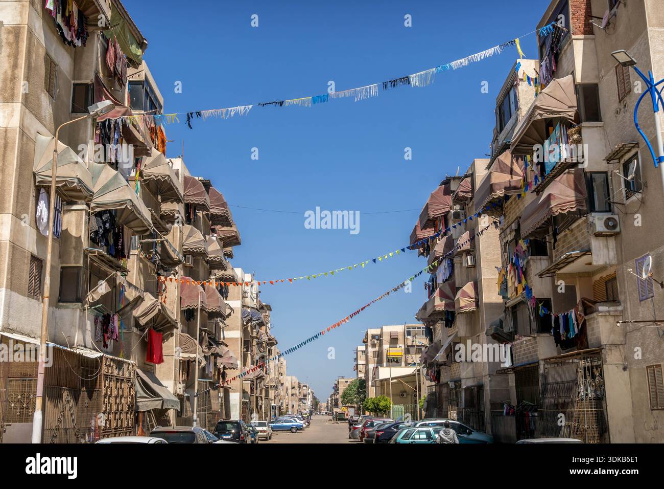 Ramadan-Dekorationen, Fanous und Khayamiyya über Wohngebäuden in Port Said Apartmentstraße, ägyptisches Nachbarschaftsleben. Stockfoto