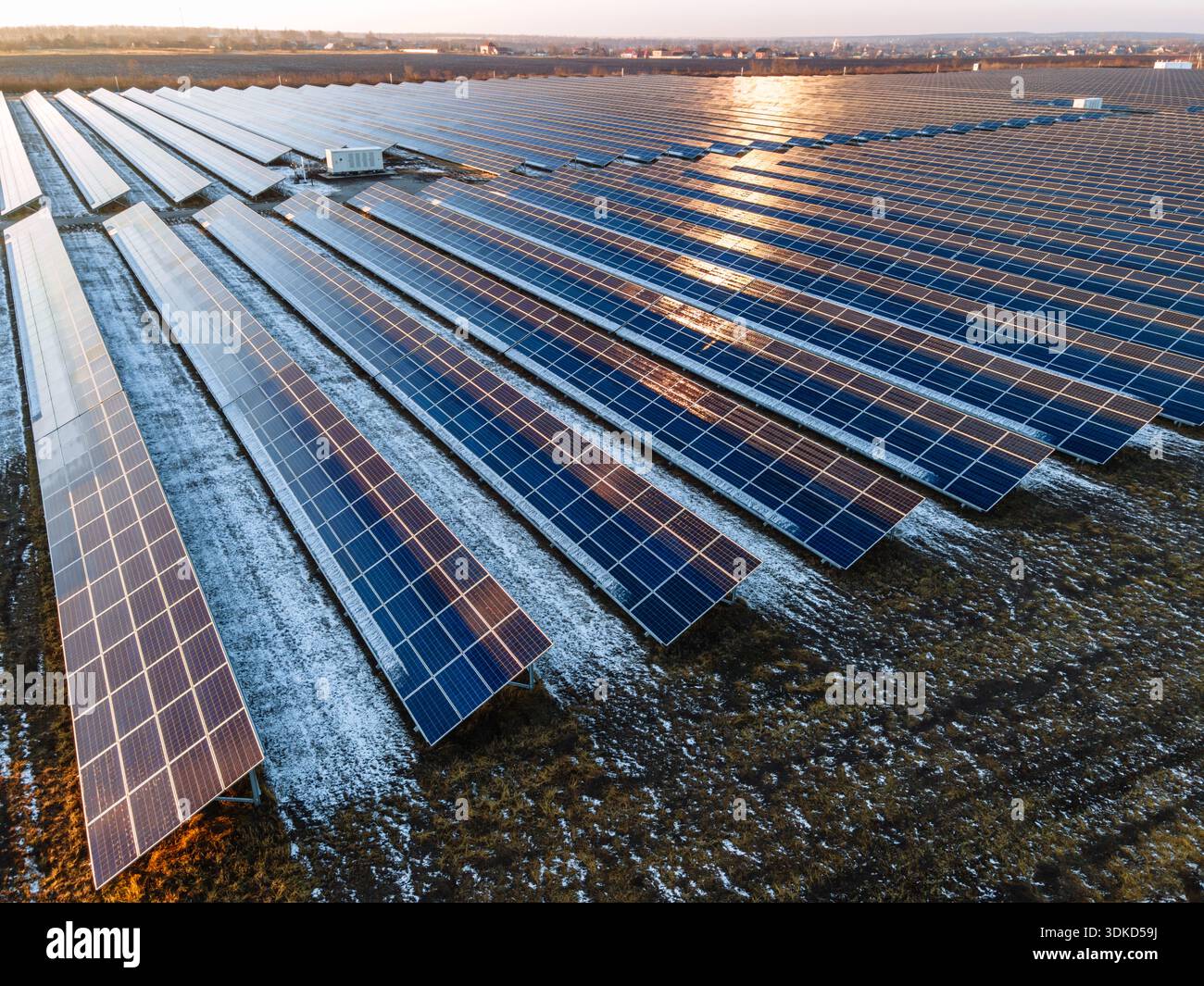 Luftaufnahme eines ausgedehnten Solarkraftwerks mit langen Reihen von Photovoltaik-Panels auf freiem Land. Erzeugung erneuerbarer Energie und sauberer Elektrizität Stockfoto