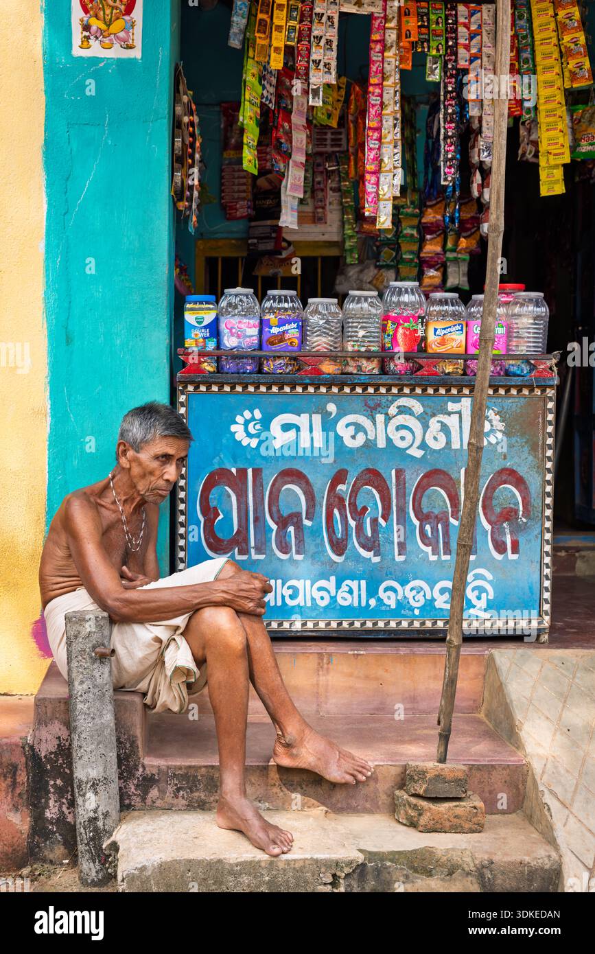 Ein älterer Mann ruht vor seinem Laden, Odisha, Indien Stockfoto