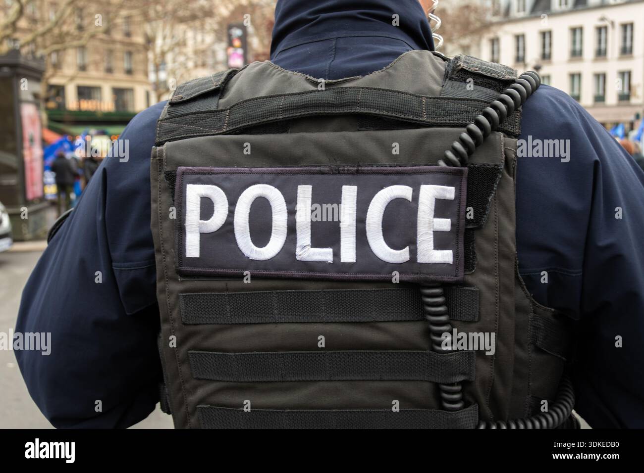 "POLIZEI"-Schild auf der taktischen Weste eines französischen Polizisten in einer Straße von Paris. Konzepte der Strafverfolgung und polizeilichen Untersuchung in Frankreich Stockfoto