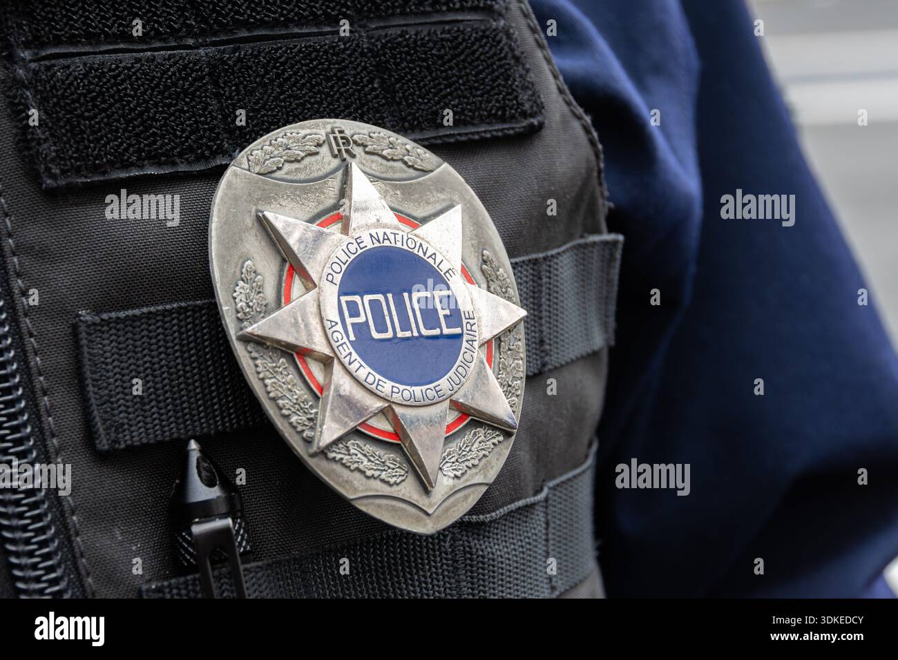 Nahaufnahme eines sternförmigen "Police nationale - Agent de Police Judiciaire"-Abzeichens, das auf der taktischen Weste eines französischen Polizisten getragen wurde Stockfoto