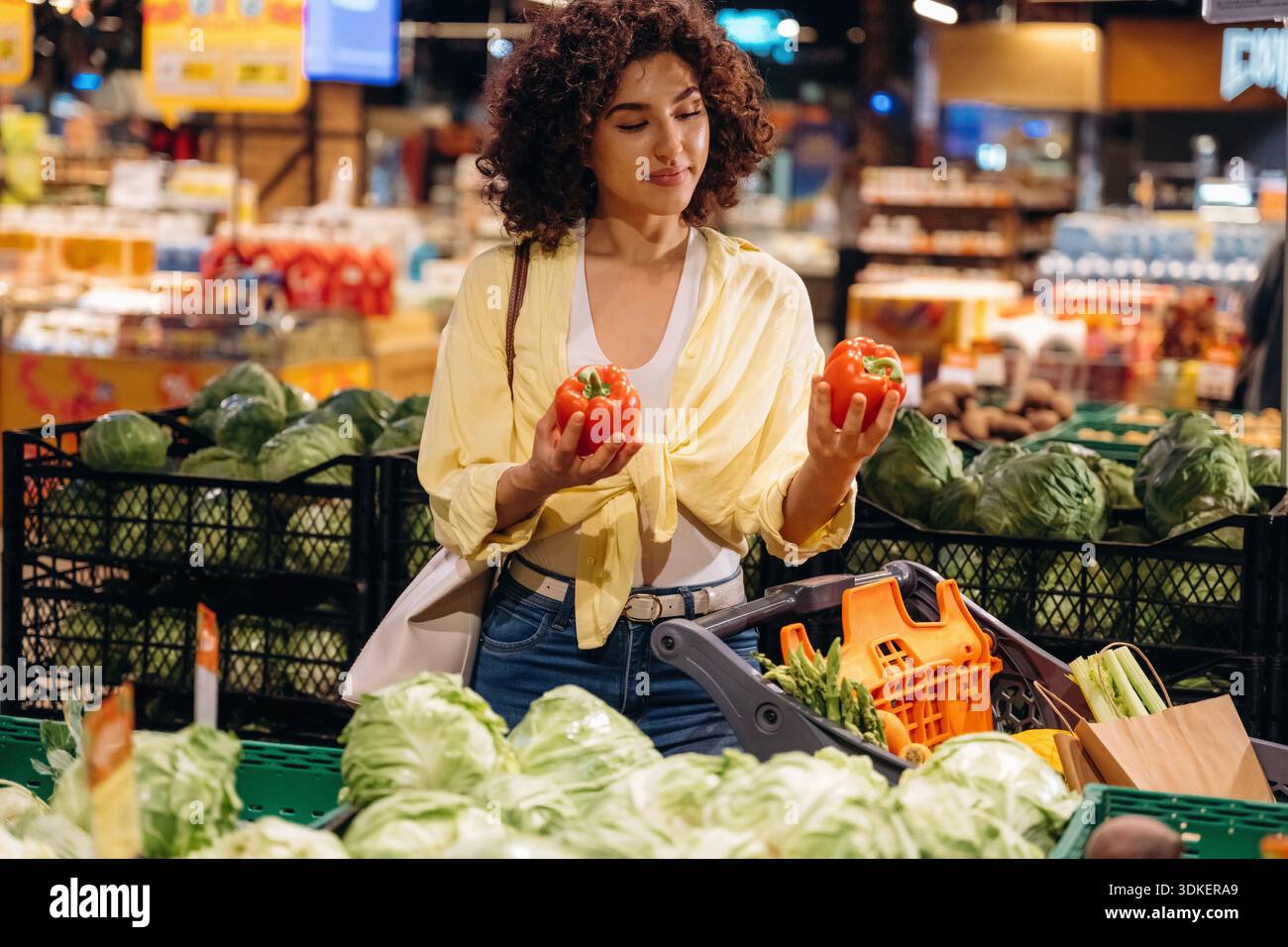 Gesundes Esskonzept, mit Pfeffer. Die wunderschöne Frau ist im Supermarkt. Stockfoto
