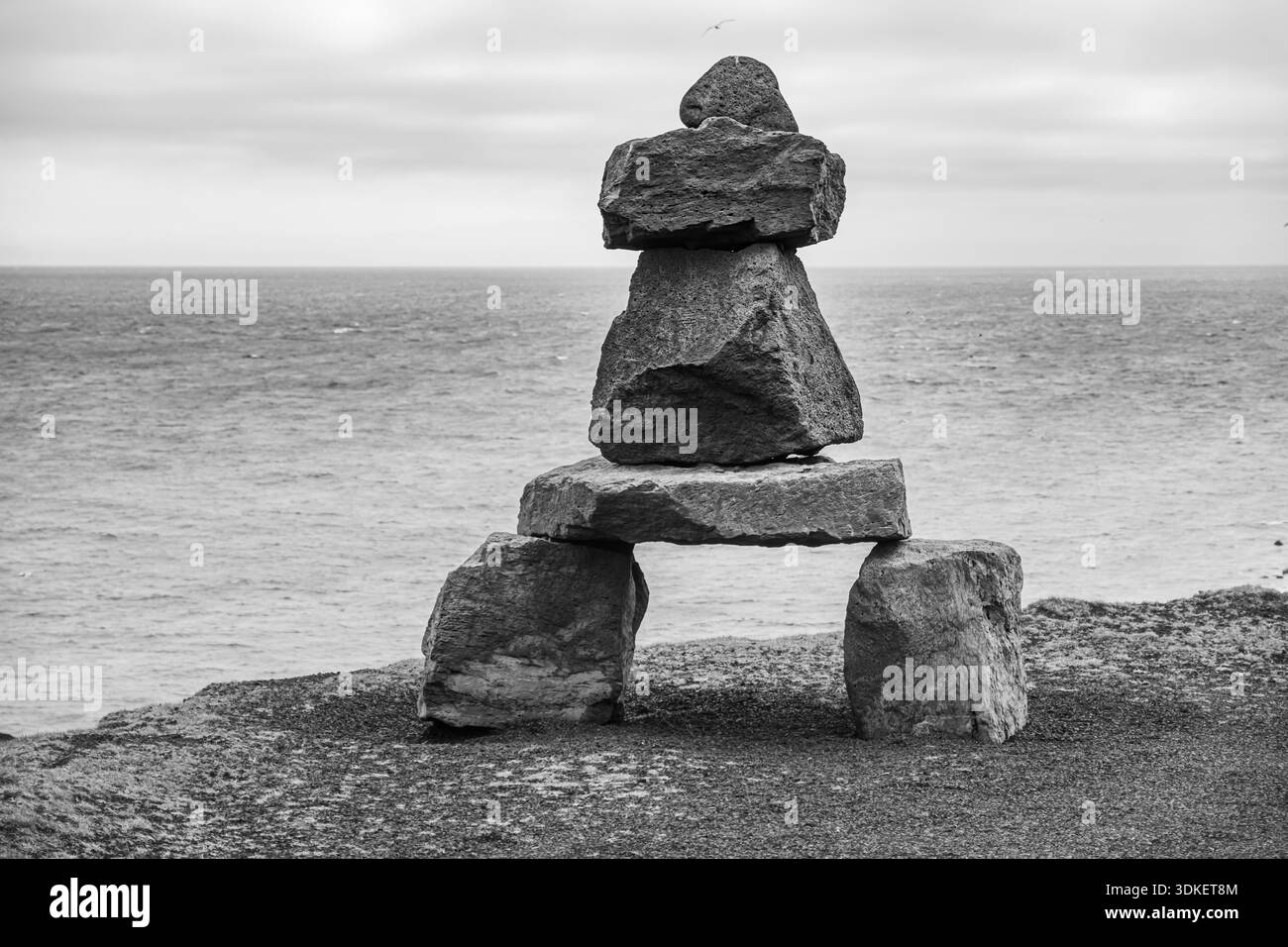 Cairns on Coastal Cliff – Stacked Rocks in Balance über Wasser Stockfoto