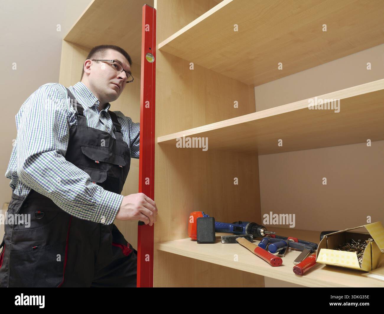 Tischler mit Wasserwaage für das Planieren montiert Garderobe Möbel Stockfoto
