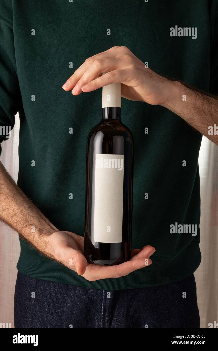 Modell der Rotweinflasche, leeres weißes Papieretikett, Produktpräsentation, Modell der Weinmarke. Waldgrüne Marineblau-Creme Stockfoto