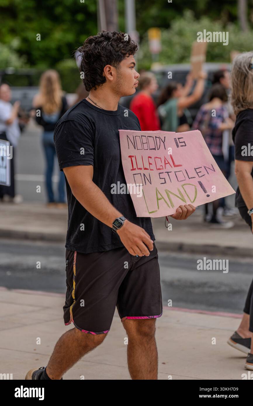 Demonstranten halten das Schild „Niemand ist illegal auf gestohlenem Land“, während Demonstranten gegen EIS kämpfen, während die Bewegung „No Kings“ zu politischen Veränderungen aufruft. Stockfoto