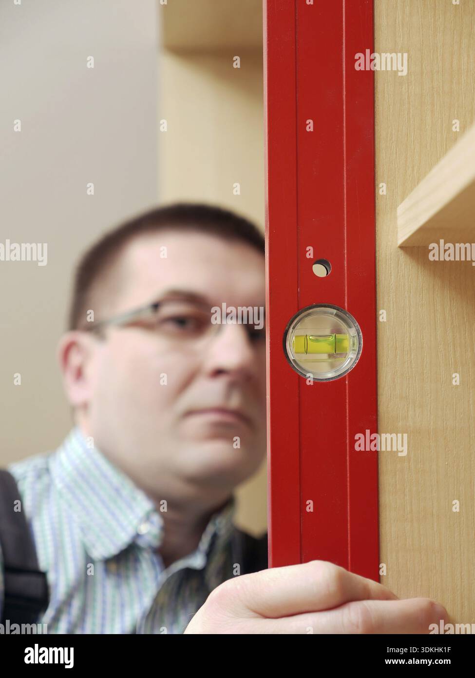 Tischler mit Wasserwaage für das Planieren montiert Garderobe Möbel Stockfoto